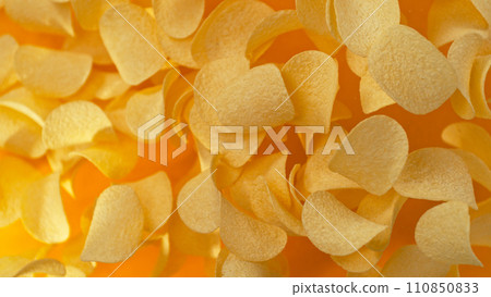 Freeze motion of flying fried potatoes chips on yellow background 110850833