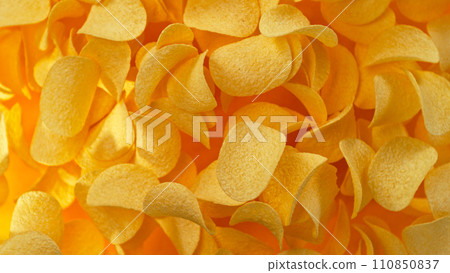 Freeze motion of flying fried potatoes chips on yellow background 110850837