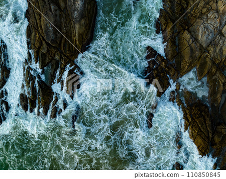 Bird eye view seashore with big wave crashing on rock cliff. Beautiful waves sea surface in sunny day summer background, Amazing seascape top view seacoast landscape view 110850845