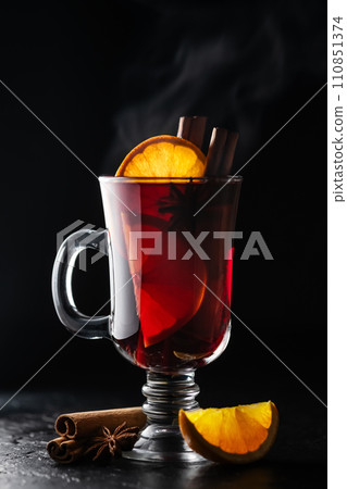 Hot mulled wine in a glass with slice of fresh orange Hot mulled wine in a glass with slice of fresh orange 110851374