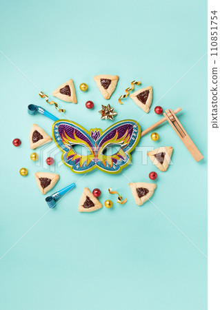 Purim Jewish Hamantaschen Cookies, Carnival Mask, Noisemaker on Blue Mint Green Background. Purim Celebration, Jewish Carnival Holiday Concept. Purim Jewish Hamantaschen Cookies, Carnival Mask, Noisemaker on Blue Mint Green Background. Purim Celebration, Jewish Carnival Holiday Concept. 110851754