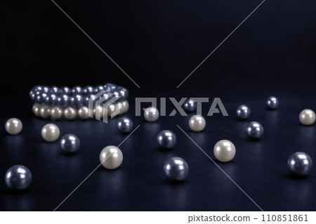 White and gray pearls on black background 110851861