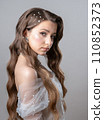 A bride in a wedding dress with a beautiful hairstyle decorated with pearls. 110852373
