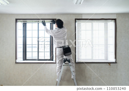 Interior contractor inspecting blinds 110853240