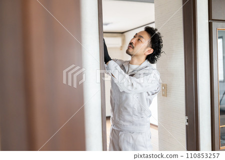 A craftsman adjusting the door hinges A craftsman adjusting the door hinges 110853257