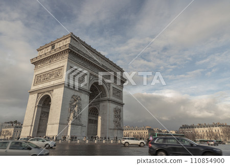 Famous Arc de Triomphe (Triumphal Arch) at the city center of Paris and traffic trails in Chaps Elysees. Famous Arc de Triomphe (Triumphal Arch) at the city center of Paris and traffic trails in Chaps Elysees. 110854900