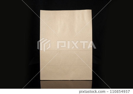 Recyclable craft paper bag for purchases, gifts and takeaway food mock up on black background. Environmentally friendly than single-use plastic bags Recyclable craft paper bag for purchases, gifts and takeaway food mock up on black background. Environmentally friendly than single-use plastic bags 110854937