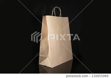 Recyclable craft paper bag for purchases, gifts and takeaway food mock up on black background. Environmentally friendly than single-use plastic bags 110855069