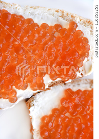 Red salmon caviar on bread and butter. A sandwich with caviar and butter on a plate. Red salmon caviar on bread and butter. A sandwich with caviar and butter on a plate. 110855255