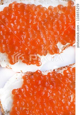 Red salmon caviar on bread and butter. A sandwich with caviar and butter on a plate. 110855259