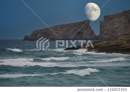 Moon rising between the cliffs of a Mediterranean beach Moon rising between the cliffs of a Mediterranean beach 110855303