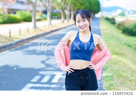 一位年輕女性透過運動、身體化妝、飲食、跑步服、運動胸罩展現自己苗條的身材和腹部 一位年輕女性透過運動、身體化妝、飲食、跑步服、運動胸罩展現自己苗條的身材和腹部 110855428