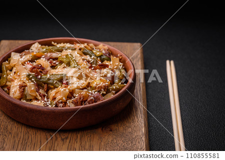 Delicious Asian dish udon with hot peppers, green beans, spices and herbs Delicious Asian dish udon with hot peppers, green beans, spices and herbs 110855581