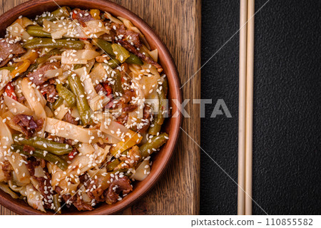 Delicious Asian dish udon with hot peppers, green beans, spices and herbs Delicious Asian dish udon with hot peppers, green beans, spices and herbs 110855582