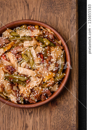 Delicious Asian dish udon with hot peppers, green beans, spices and herbs Delicious Asian dish udon with hot peppers, green beans, spices and herbs 110855583