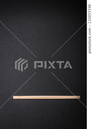 Light wooden chopsticks on a blank background as a backdrop for an Asian dish 110855596