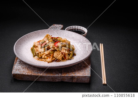 Delicious Asian dish udon with hot peppers, green beans, spices and herbs Delicious Asian dish udon with hot peppers, green beans, spices and herbs 110855618