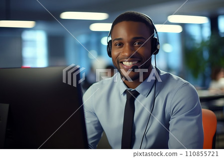 A smiling African-American man with headphones and a microphone in a call center A smiling African-American man with headphones and a microphone in a call center 110855721