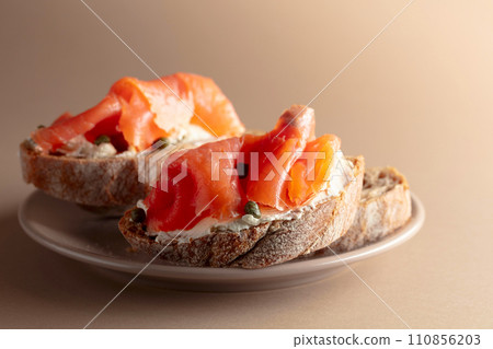 Sandwich with smoked trout, cream cheese, and capers. 110856203