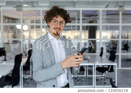Expert young businessman with a pleasant demeanor working at his office, showcasing competence and dedication with a focused yet positive emotional state. Expert young businessman with a pleasant demeanor working at his office, showcasing competence and dedication with a focused yet positive emotional state. 110856219