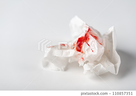 Fresh red blood stained on tissue paper on white table Fresh red blood stained on tissue paper on white table 110857351