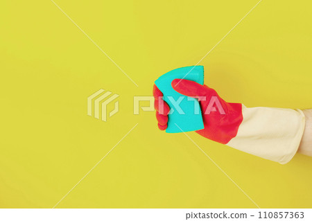 Hand in a rubber glove holds a sponge Hand in a rubber glove holds a sponge 110857363