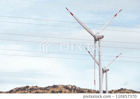 View of wind farm with high wind turbines for generation electricity View of wind farm with high wind turbines for generation electricity 110857370