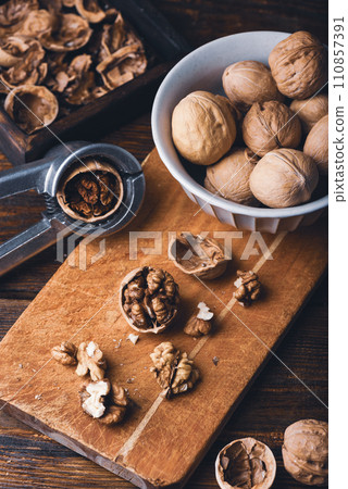 Cracked walnuts on cutting board 110857391