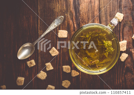 Cup of herbal tea with brown tea sugar Cup of herbal tea with brown tea sugar 110857411