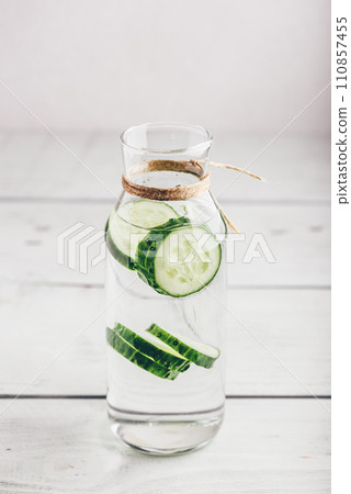 Infused water with sliced cucumber in bottle 110857455
