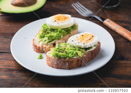 Avocado toast with cream cheese and boiled egg for breakfast 110857503