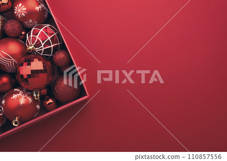 Red Christmas baubles decoration in the box on red background 110857556