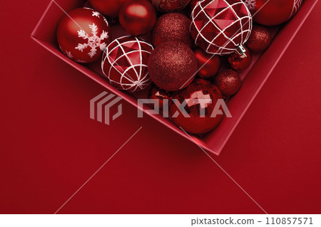 Red Christmas baubles decoration in the box on red background Red Christmas baubles decoration in the box on red background 110857571