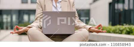 Close up of business woman sitting in lotus position and meditation during break with distance work 110858943