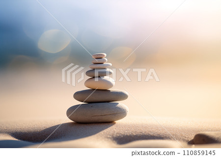 Zen stones stack on sand waves in a minimalist setting for balance and harmony 110859145