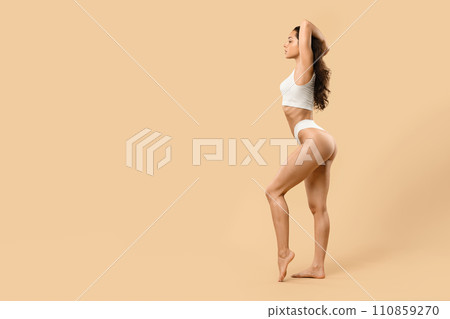 Confident young woman in underwear showcasing her natural beauty and toned physique Confident young woman in underwear showcasing her natural beauty and toned physique 110859270