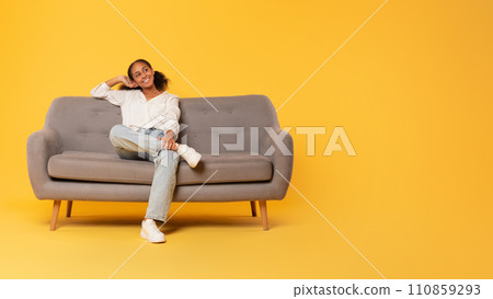 Relaxed African American teen student girl lounging on sofa, studio Relaxed African American teen student girl lounging on sofa, studio 110859293