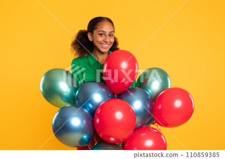 black teen girl posing with bunch of colorful balloons, studio black teen girl posing with bunch of colorful balloons, studio 110859385