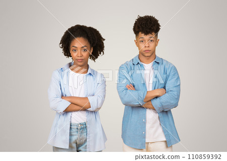 An African American young woman and man stand side-by-side with their arms crossed An African American young woman and man stand side-by-side with their arms crossed 110859392