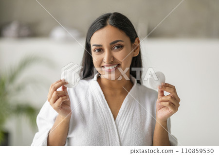 Closeup of attractive young indian woman showing cotton pads 110859530