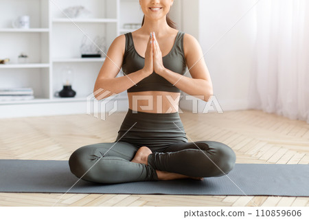 Focused asian woman enjoying peaceful yoga session in lotus position at home Focused asian woman enjoying peaceful yoga session in lotus position at home 110859606