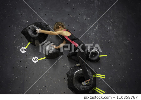 Brave girl child climbing artificial wall at 110859767