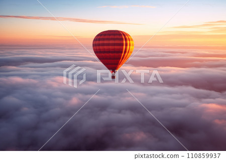 Colorful hot air balloon floats over a sea of clouds at sunset 110859937