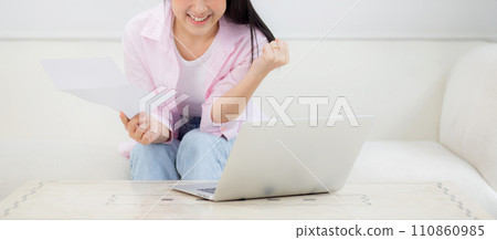 Young asian business woman working on laptop computer and looking graph and chart. 110860985