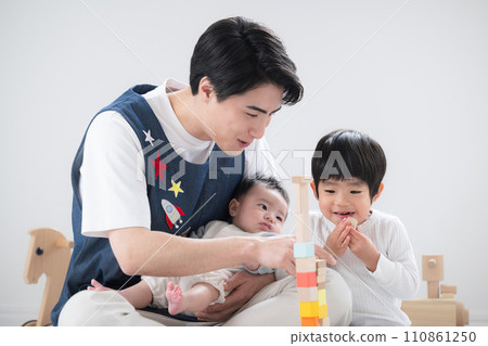 Image of a male nursery teacher changing jobs: Smiling nursery teacher and toddler playing with building blocks indoors 110861250