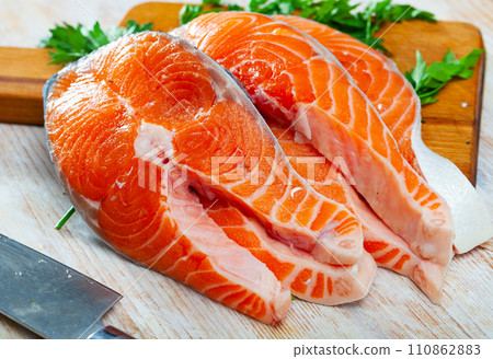 Raw salmon fillet on wooden table 110862883