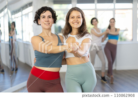 Cheerful girls learn to dance together modern and classical dances in dance studio 110862908