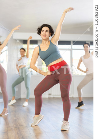 Female teacher conducts modern dance lessons for group of girls 110862922