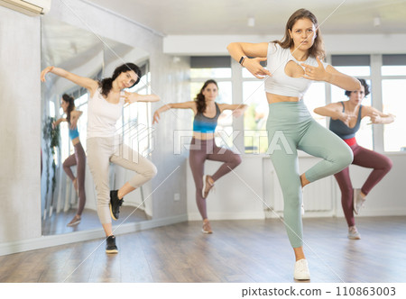 Enthusiastic young girl honing hip-hop moves in dance studio 110863003