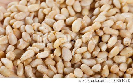Pine nuts scattered on wooden surface 110863038